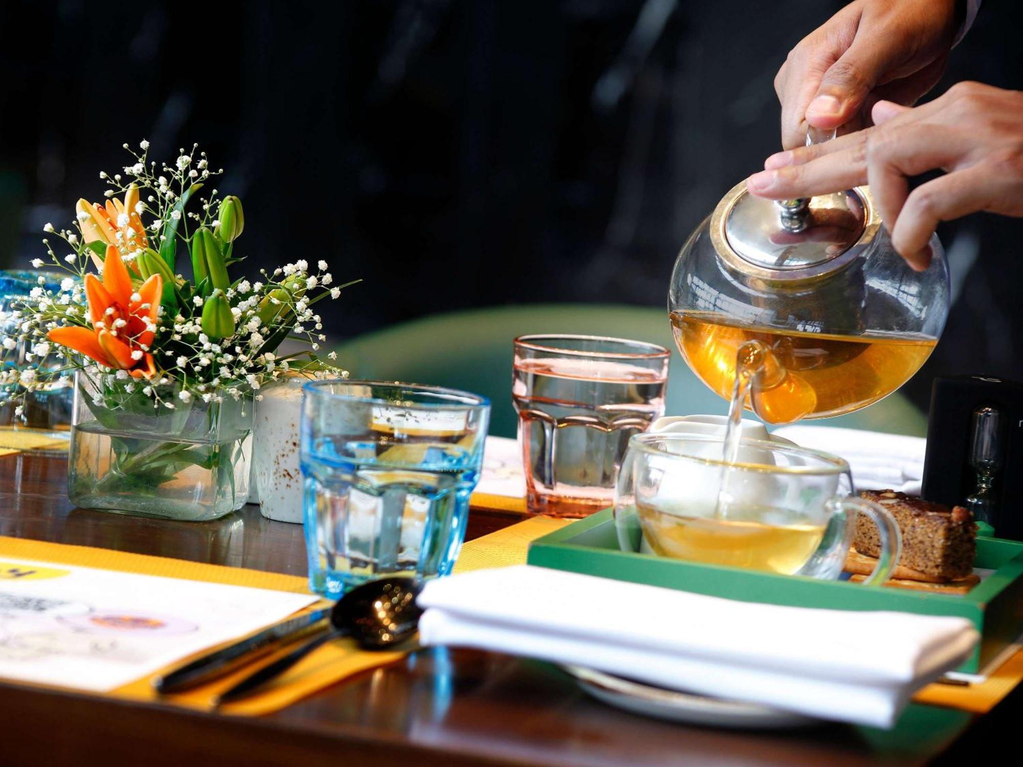 Novotel Kolkata Hotel And Residences Dış mekan fotoğraf A server pours tea at a restaurant