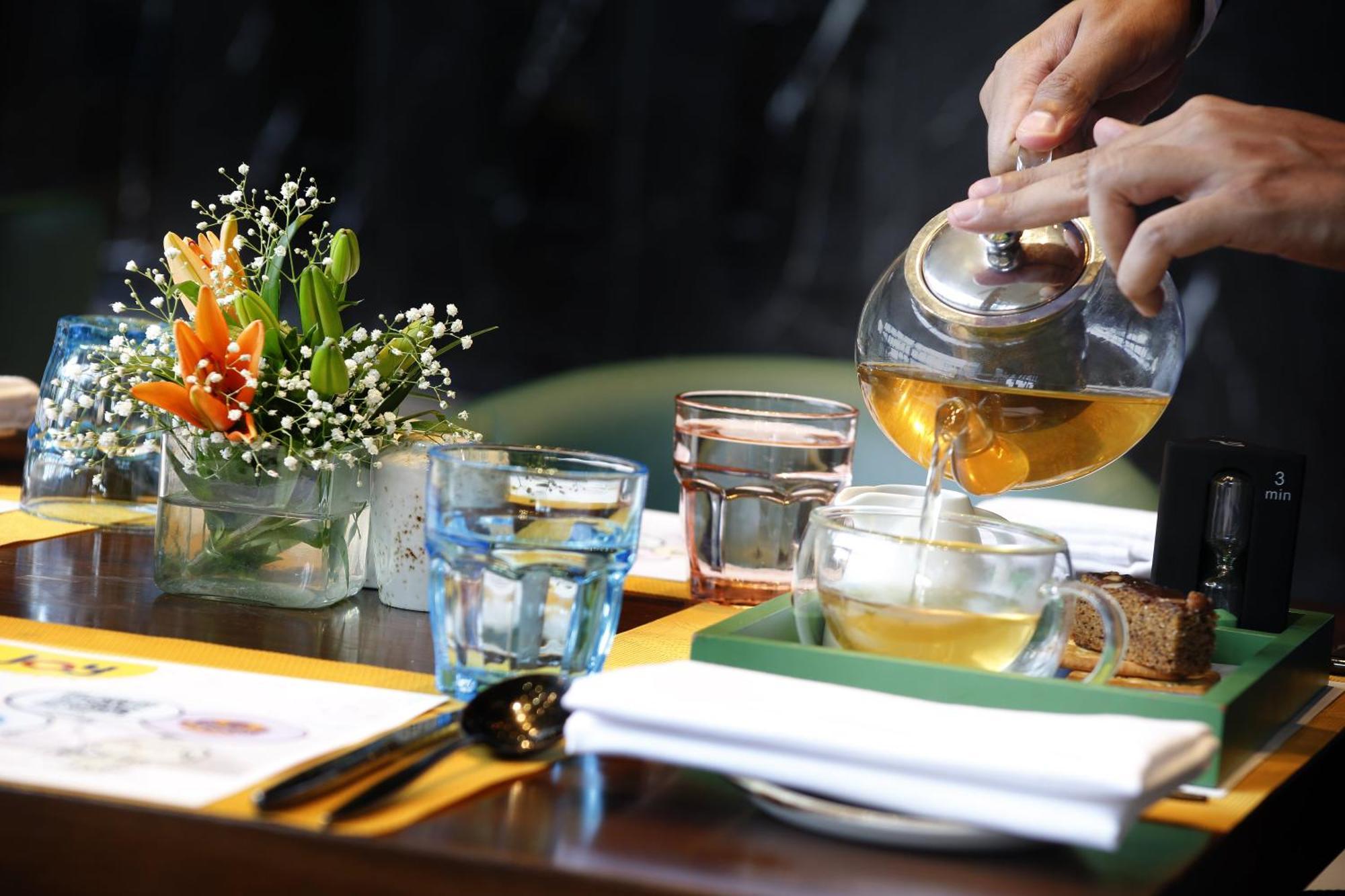 Novotel Kolkata Hotel And Residences Dış mekan fotoğraf A server pours tea at a restaurant
